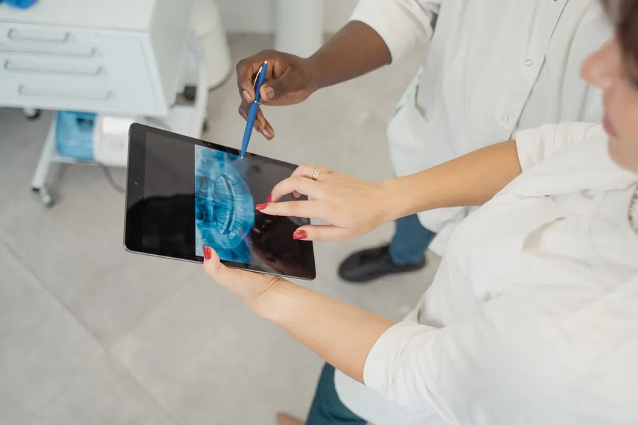 Dentist reviewing 3D CBCT scan to plan All-on-4 or All-on-6 treatment for a UK patient at Taki Dent clinic in Antalya
